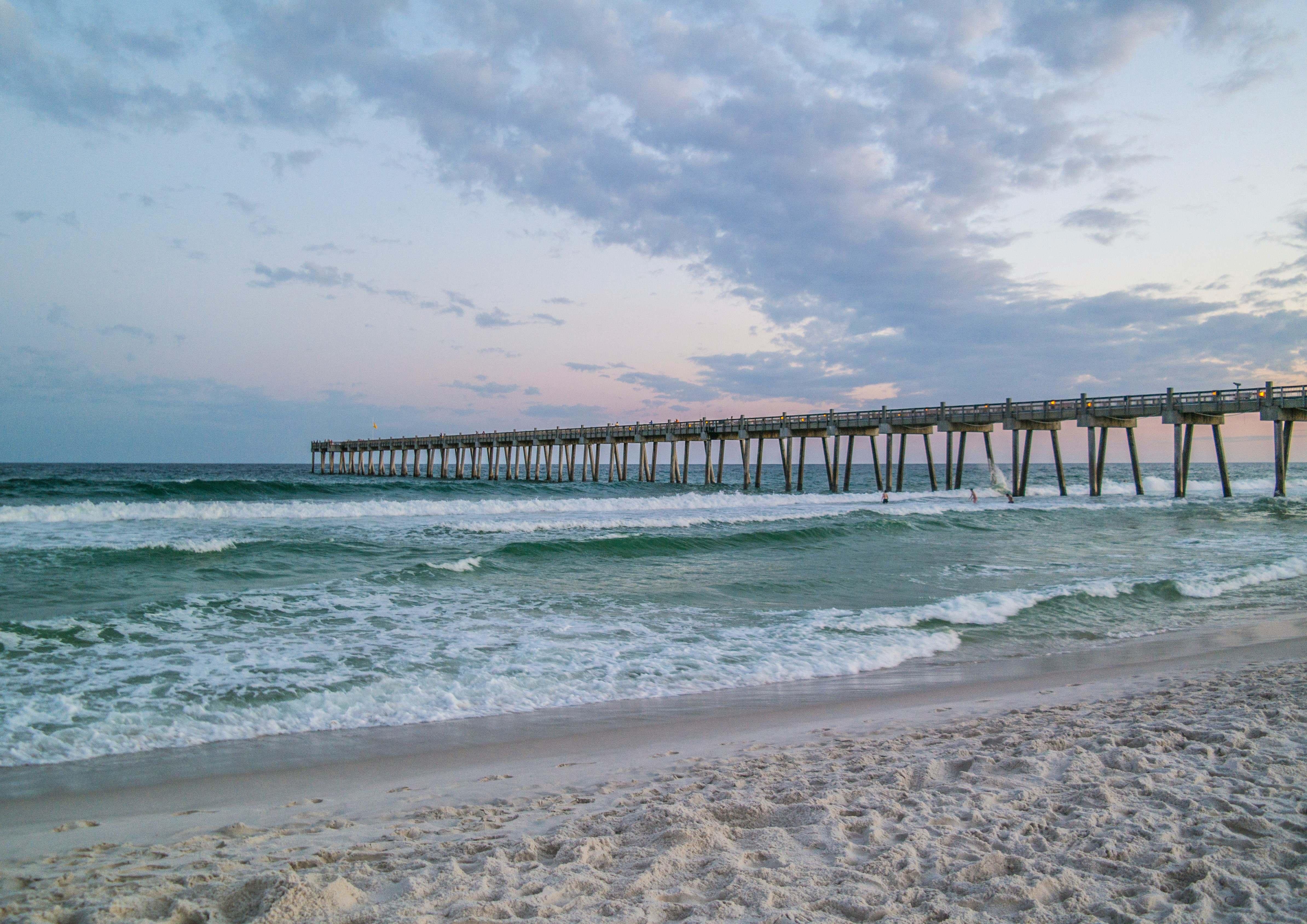 Pensacola Beach pier at dusk, emerald water and white sand